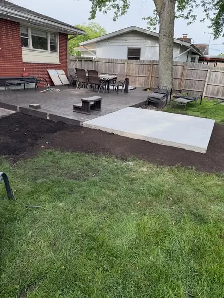 Backyard patio project with fresh grading beside an existing deck